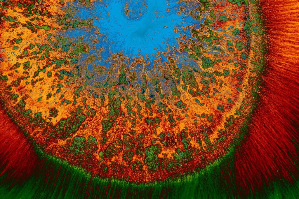 A colorful abstract artwork featuring a vibrant blend of orange, blue, and green hues.